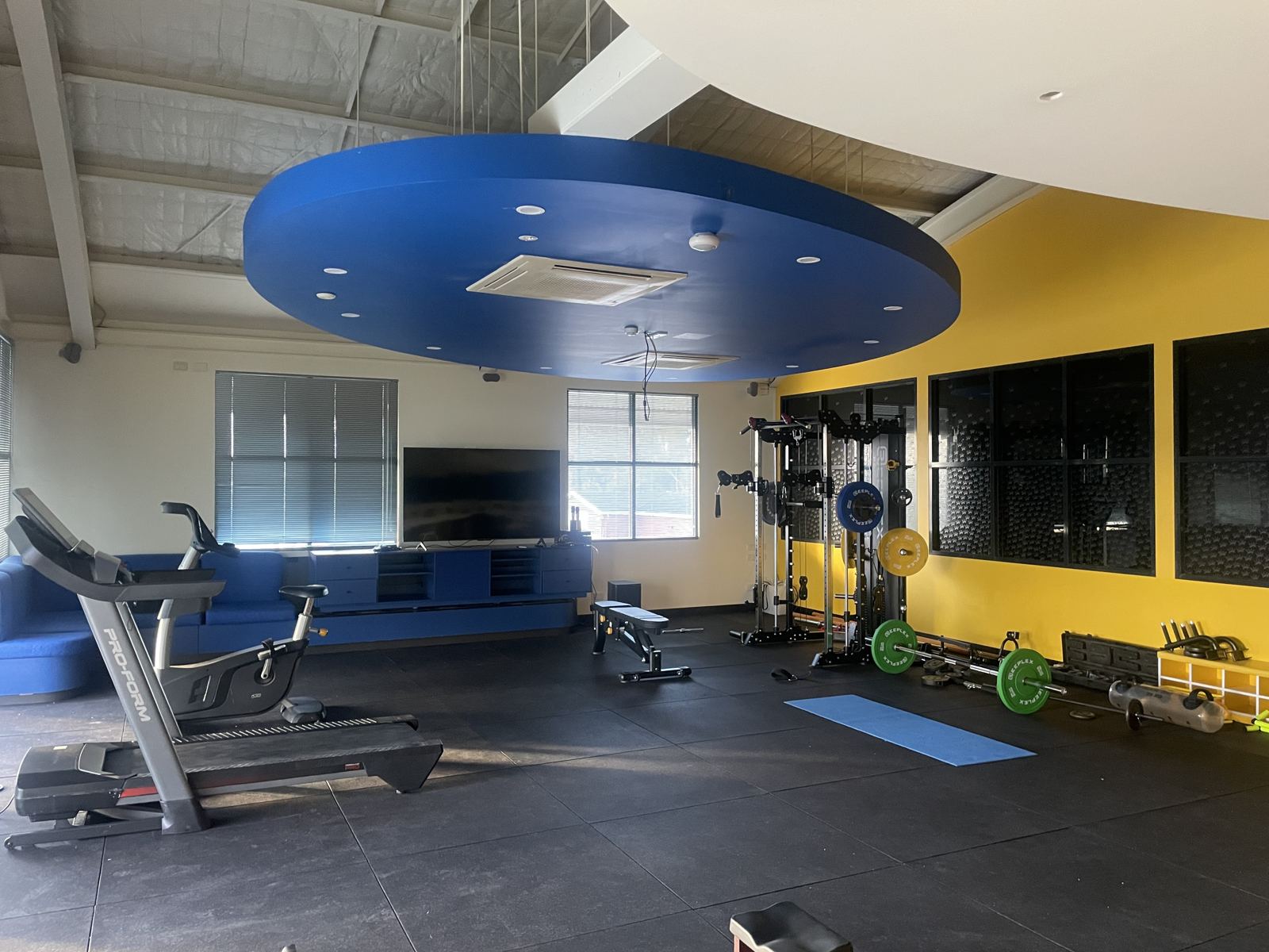 The strength and rehab gym at FM Physiotherapy, with squat rack, barbells and treadmill